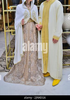 Mariage marocain. Un marié portant un djellaba tient sa mariée qui porte un caftan marocain traditionnel Banque D'Images