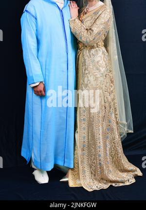 Mariage marocain. Un marié portant un djellaba tient sa mariée qui porte un caftan marocain traditionnel Banque D'Images