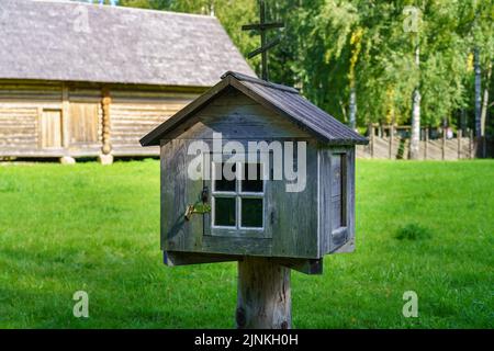 Ancienne boîte aux lettres en bois sur un poste à l'extérieur de la maison. Banque D'Images