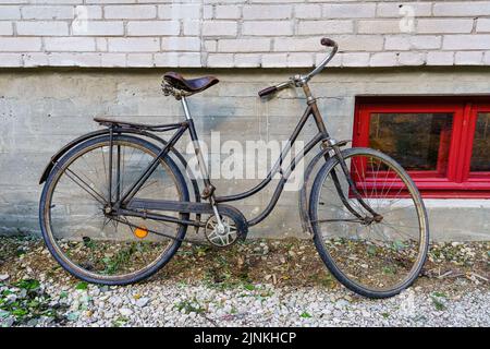 Vieux vélo rouillé stationné sur le mur d'un vieux bâtiment. Banque D'Images