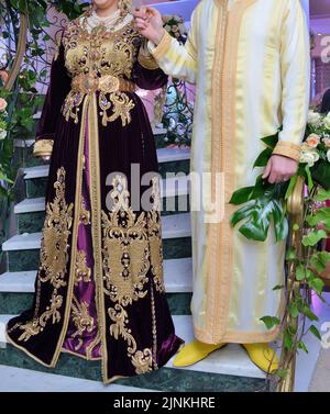 Mariage marocain. Un marié portant un djellaba tient sa mariée qui porte un caftan marocain traditionnel Banque D'Images