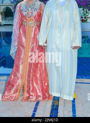 Mariage marocain. Un marié portant un djellaba tient sa mariée qui porte un caftan marocain traditionnel Banque D'Images