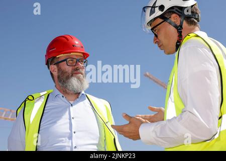 Rodby, Danemark. 12th août 2022. Claus Ruhe Madsen (l, indépendant), ministre des Transports du Schleswig-Holstein, s'entretient avec le directeur de projet Femern A/S Matthias Laugenstein sur le site de construction du tunnel de la ceinture de Fehmarn. La liaison de transport de 17,6 kilomètres entre l'Allemagne et le Danemark devrait être achevée d'ici 2029. Credit: Frank Molter/dpa/Alay Live News Banque D'Images