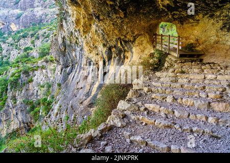 Grotte dans la montagne avec un chemin avec des marches pour les randonneurs. Banque D'Images