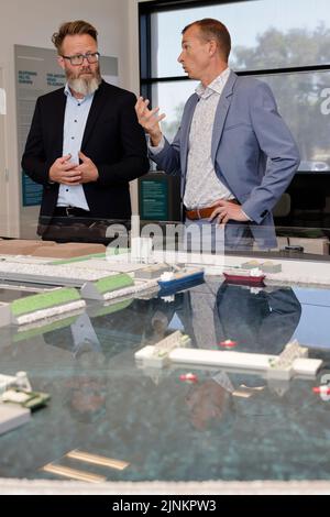 Rodby, Danemark. 12th août 2022. Claus Ruhe Madsen (l, indépendant), ministre des transports du Schleswig-Holstein, et Henrik Vincentsen, PDG de Femern A/S, parlent devant un modèle du tunnel de la ceinture de Fehmarn. La liaison de transport de 17,6 kilomètres entre l'Allemagne et le Danemark devrait être achevée d'ici 2029. Credit: Frank Molter/dpa/Alay Live News Banque D'Images