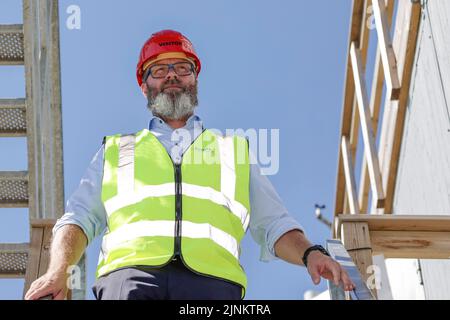 Rodby, Danemark. 12th août 2022. Claus Ruhe Madsen (non-parti), ministre des Transports du Schleswig-Holstein, descend un escalier sur le site de construction du tunnel de la ceinture de Fehmarn. La liaison de transport de 17,6 kilomètres entre l'Allemagne et le Danemark devrait être achevée d'ici 2029. Credit: Frank Molter/dpa/Alay Live News Banque D'Images