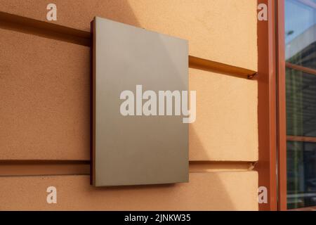 maquette pour logo. panneau carré, vide, classique contre un mur jaune Banque D'Images