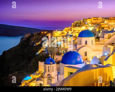 Soirée avec dômes bleus classiques illuminés, église et architecture blanche Santorin , Oia, Grèce, Europe Mer Egéé, Méditerranée Banque D'Images