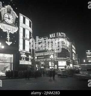 1960, historique, centre de Londres, enseignes publicitaires au néon à Piccadilly Cicrus la nuit, les gens à l'extérieur se sont rassemblés à l'extérieur des bijoutiers, 'squi & Lawence'. H. Samuel a introduit Saqui & Lawrence en 1908 et a continué à faire la tradede en 1980s. Également un panneau pour le London Institute & Morris School of coiffure, qui a fonctionné pendant les années 60, 70 et 80. Détenue et gérée par le « professeur » Alfred Morris, la Morris School a été la première école de beauté du Royaume-Uni. Banque D'Images