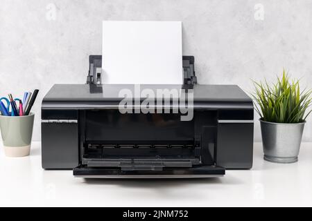 Imprimante jet d'encre avec feuille de papier vierge sur le bureau. Maquette de modèle Banque D'Images