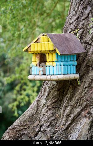 Boîte de nidification ou cabane à oiseaux faite de bouchons en liège peints en jaune et bleu - couleurs du drapeau national ukrainien Banque D'Images