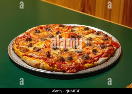 pizza au four en brique cheesy avec du bœuf et des tomates Banque D'Images