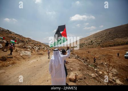 Naplouse, Palestine. 12th août 2022. Un manifestant palestinien agite un drapeau lors de la manifestation contre les colonies israéliennes dans le village de Beit Dajan près de la ville de Naplouse, en Cisjordanie. (Photo de Nasser Ishtayeh/SOPA Images/Sipa USA) crédit: SIPA USA/Alay Live News Banque D'Images