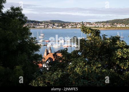 Vue d'été depuis les remparts de Conwy, dans le nord du pays de Galles, surplombant les bateaux amarrés sur l'estuaire de la rivière Conwy, avec Deganwy Town au loin Banque D'Images