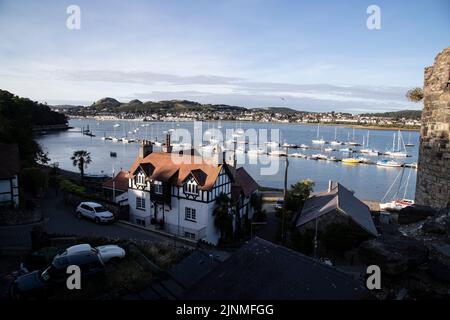 Vue d'été depuis les remparts de Conwy, dans le nord du pays de Galles, surplombant les bateaux amarrés sur l'estuaire de la rivière Conwy, avec Deganwy Town au loin Banque D'Images