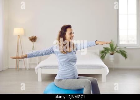 Bonne bonne santé jeune femme faisant des exercices de gymnastique avec une balle de yoga pendant la grossesse Banque D'Images