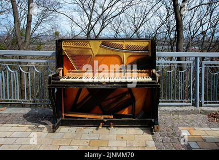 Piano droit déversé et endommagé d'époque avec les pièces internes exposées sur la rue à Kiev Ukraine Banque D'Images