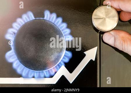 Prix de l'essence. Les chaînes d'approvisionnement et la crise du gaz énergétique. Cuisinière à gaz avec une flamme brûlante et une flèche graphique pointant vers le haut. La main de l'homme règle l'alimentation en gaz Banque D'Images