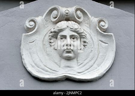 Cartouche avec mascaron femelle sur la façade de l'ancien bâtiment à Kiev en Ukraine Banque D'Images