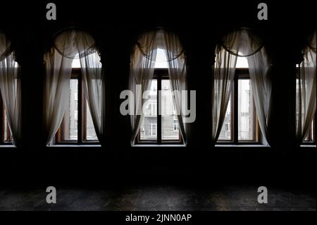 Chambre sombre avec rideau avant les vieilles fenêtres Banque D'Images