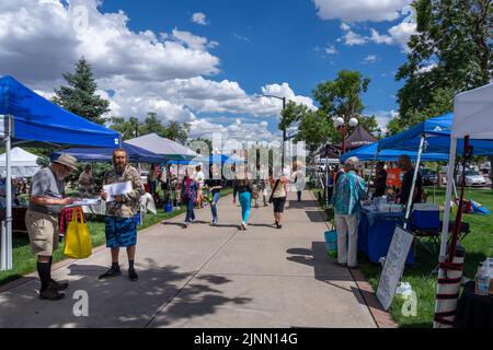 Colorado Springs, CO - 6 juillet 2022: Les gens magasinent et un homme collecte des signatures à la ferme et le marché d'art du Colorado situé sur le terrain de Banque D'Images