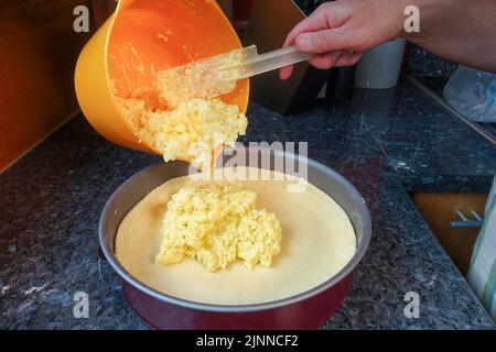 Cuisine souabe, préparation du gâteau de pommes de terre Haertsfeld, remplissage de la base de pâte à caillé avec un mélange de pommes de terre et de crème sure, plat à pâtisserie, plateau à gâteau, trempette Banque D'Images