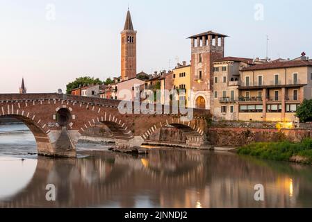 Pont voûté Ponte Pietra, traverse la rivière Adige, derrière elle des maisons résidentielles colorées, Basilica di Sant Anastasia, Vérone, Vénétie, Italie Banque D'Images