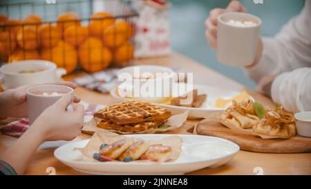 Un couple dans le restaurant ayant un petit déjeuner avec des gaufres et des crêpes Banque D'Images