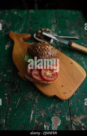 Rouleau de graines de tournesol avec tomates et olives sur bois Banque D'Images