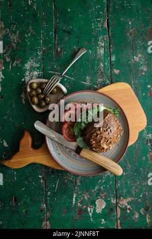 Rouleau de graines de tournesol avec tomates et olives sur bois Banque D'Images