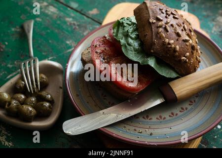 Rouleau de graines de tournesol avec tomates et olives sur bois Banque D'Images