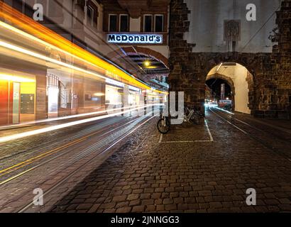 Longue exposition d'un tramway dans le centre-ville de Fribourg la nuit, Fribourg, Allemagne Banque D'Images