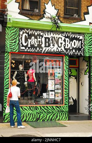 Une jeune femme fume une cigarette devant Crash Boom Bang, une boutique de punk et alternative juste à côté de South Street dans South Philadelphia Banque D'Images