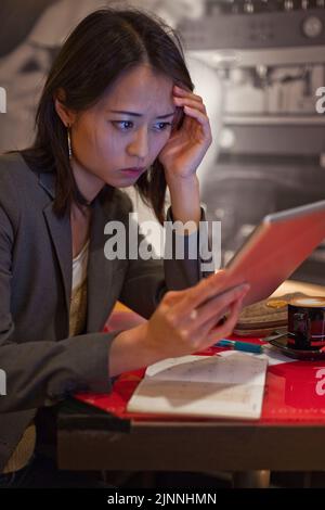 Jeune femme asiatique avec iPad et capuchino dans un café, Tokyo, Japon Banque D'Images