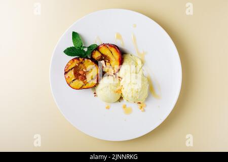 Pêches grillées et crème glacée au citron avec du miel. Banque D'Images