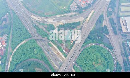 Vue aérienne de haut en bas sur un énorme échangeur à plusieurs niveaux sur la ville de Jakarta lors d'une journée ensoleillée d'été avec peu de circulation Banque D'Images