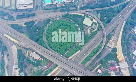 Vue aérienne de haut en bas sur un énorme échangeur à plusieurs niveaux sur la ville de Jakarta lors d'une journée ensoleillée d'été avec peu de circulation Banque D'Images