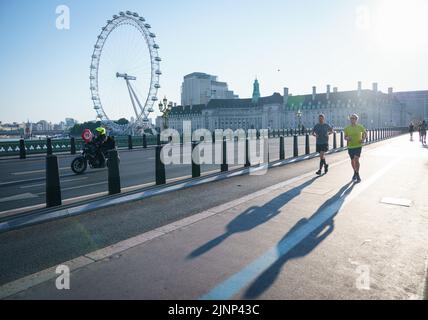 Les coureurs du matin sur le pont de Westminster, Londres, comme une sécheresse a été déclarée pour certaines parties de l'Angleterre après l'été le plus sec depuis 50 ans. Date de la photo: Samedi 13 août 2022. Banque D'Images