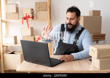 Petit entrepreneur de démarrage d'entreprise ou indépendant indian homme utilisant ordinateur portable avec boîte, jeune homme d'affaires avec la main levée, en ligne de vente emballage boîte Banque D'Images