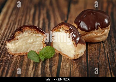 Tranché deux moitiés de pâte française, de profiterroli à la crème anglaise, gros plan. Concept de pâtisserie maison. Photo est utilisé pour le menu ou la publicité Banque D'Images