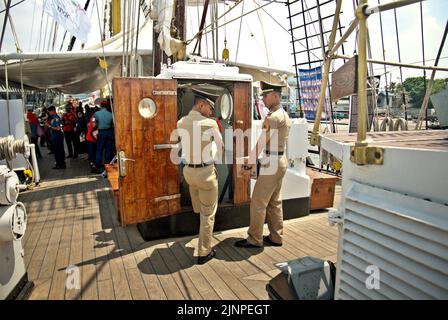 Des cadets de la Marine transportant de l'eau minérale dans des boîtes alors qu'ils sont sur le point d'entrer dans la chambre des cadets de KRI Dewaruci (Dewa Ruci), un grand navire indonésien, car la goélette de type barquentine est ouverte aux visiteurs publics au port de Kolinlamil (port de la Marine) à Tanjung Priok, dans le nord de Jakarta, en Indonésie. Banque D'Images