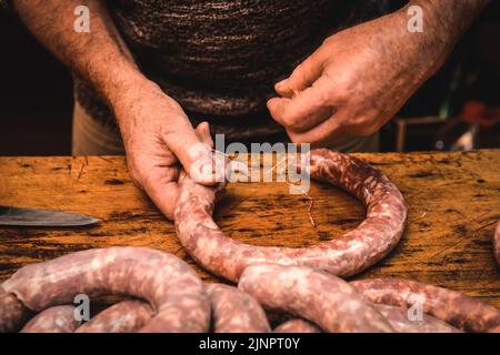 Mains travaillant sur l'élaboration de saucisses, l'abattage traditionnel argentin. Banque D'Images