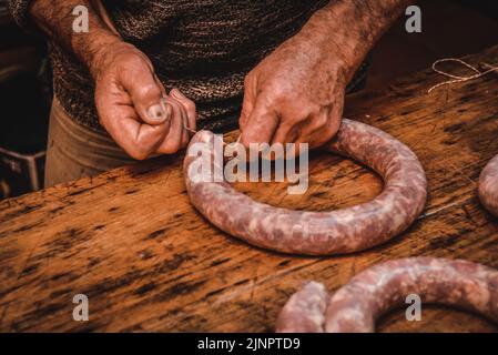 Mains travaillant sur l'élaboration de saucisses, l'abattage traditionnel argentin. Banque D'Images