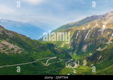 Paysage d'été pittoresque. Col de Furka dans les Alpes suisses. Une rivière de montagne traverse la vallée verte, une route en serpentin monte dans le dist Banque D'Images