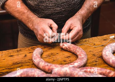 Mains travaillant sur l'élaboration de saucisses, l'abattage traditionnel argentin. Banque D'Images