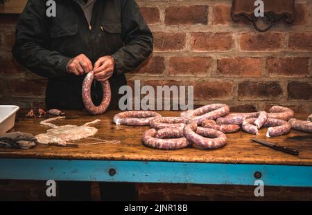 Mains travaillant sur l'élaboration de saucisses, l'abattage traditionnel argentin. Banque D'Images