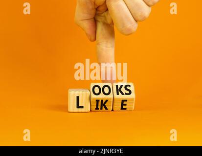 Ressemble à un symbole. Les mots concept ressemblent à des cubes en bois. Main d'homme d'affaires. Belle table orange fond orange. Affaires, citations populaires et Banque D'Images