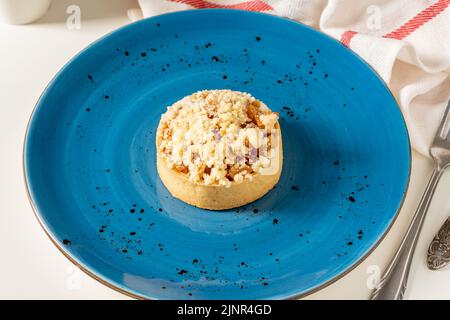 Tarte aux pommes fraîchement cuite en une seule portion sur une assiette en porcelaine bleue Banque D'Images