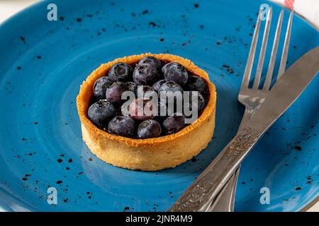 Tarte aux myrtilles fraîchement cuite sur une assiette en porcelaine bleue Banque D'Images