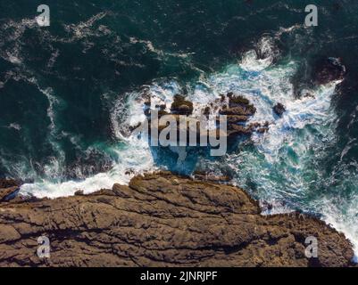 Vue imprenable sur l'océan et la côte rocheuse. Une belle surface turquoise foncé de l'eau et des vagues de mousse blanche s'écrasont contre les rochers sur le sho Banque D'Images